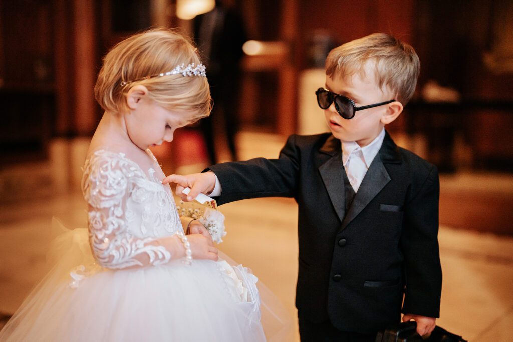 The ring bearer has a question for the flower girl.