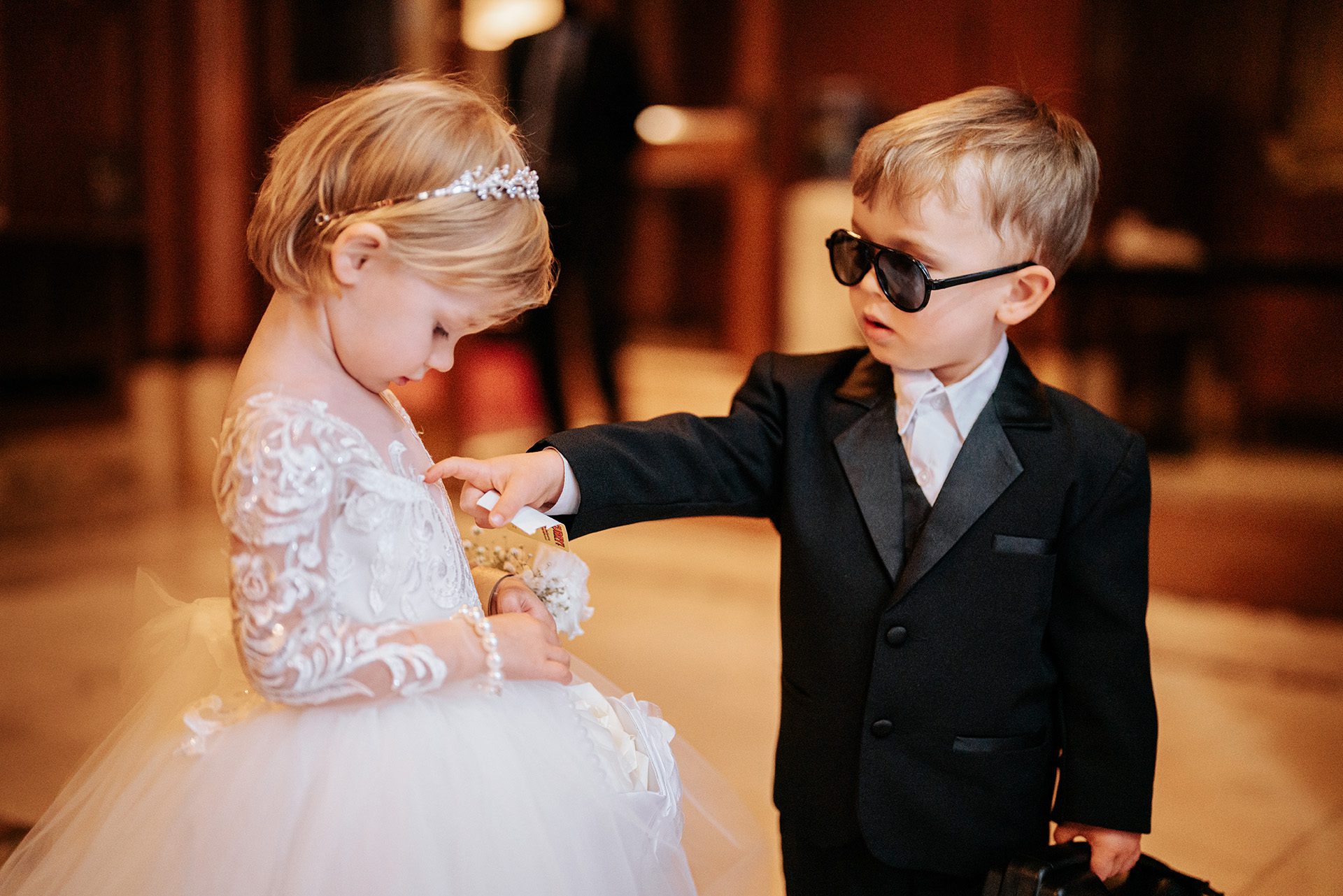 The ring bearer has a question for the flower girl.
